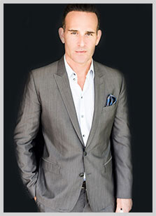 Dr. Paul Jarrod Frank of PFrankMD portrait in grey suit
